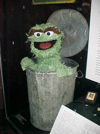 An Oscar the Grouch puppet (shown) and Sesame Street sign both reside in the Smithsonian National Museum of American History