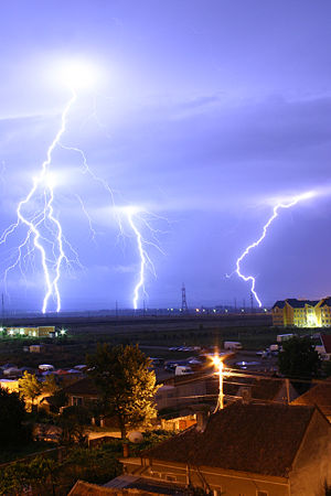 Lightning is an example of plasma present at Earth's surface. Typically, lightning discharges 30,000 amperes, at up to 100 million volts, and emits light, radio waves, x-rays and even gamma rays. Plasma temperatures in lightning can approach ~28,000 kelvin (~27,700oC) and electron densities may exceed 1024/m³.