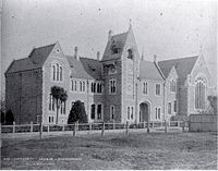 Canterbury College, designed by Benjamin Mountfort in 1877, is dominated by a central clock tower, with a medieval style great hall to the right.