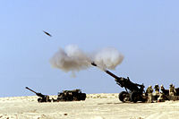 A 155 mm M198 howitzer firing a shell.