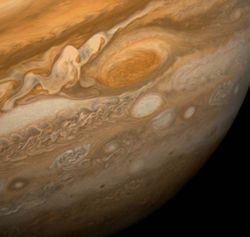 This dramatic view of Jupiter's Great Red Spot and its surroundings was obtained by Voyager 1 on February 25, 1979, when the spacecraft was 9.2 million km (5.7 million mi) from Jupiter. Cloud details as small as 160 km (100 mi) across can be seen here. The colorful, wavy cloud pattern to the left of the Red Spot is a region of extraordinarily complex and variable wave motion. To give a sense of Jupiter's scale, the white oval storm directly below the Great Red Spot is approximately the same diameter as Earth.