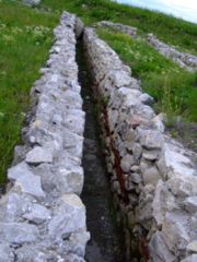 A sanitary channel at Potaissa. It is placed cross-slope with a slight decline and then exits down-slope.