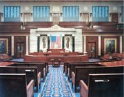 The chamber of the United States House of Representatives is located in the south wing of the Capitol building, in Washington, D.C. This photograph shows a rare glimpse of the four vote tallying boards (the blackish squares across the top), which display each member's name and vote while votes are in progress. The screens are notably used by Congressional leaders to identify which members are voting against party lines.